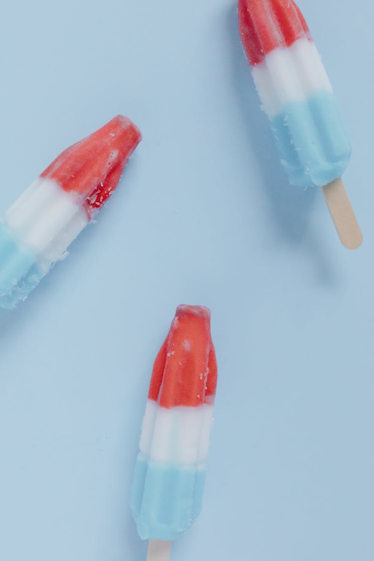 Close-Up Shot Of Ice Popsicles On A Blue Surface