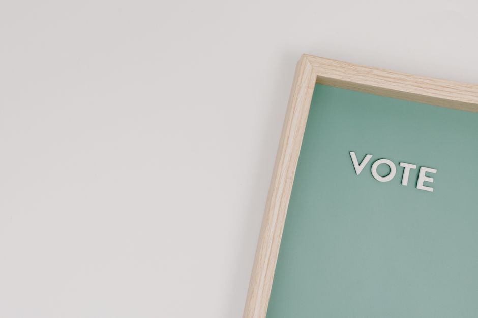 Marco de madera elegante con 'Vote' en un fondo verde, perfecto para temas de elecciones.
