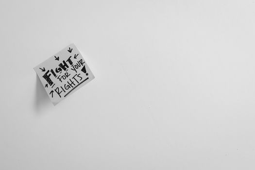 Sticky note with 'Fight for your rights' message on white surface.