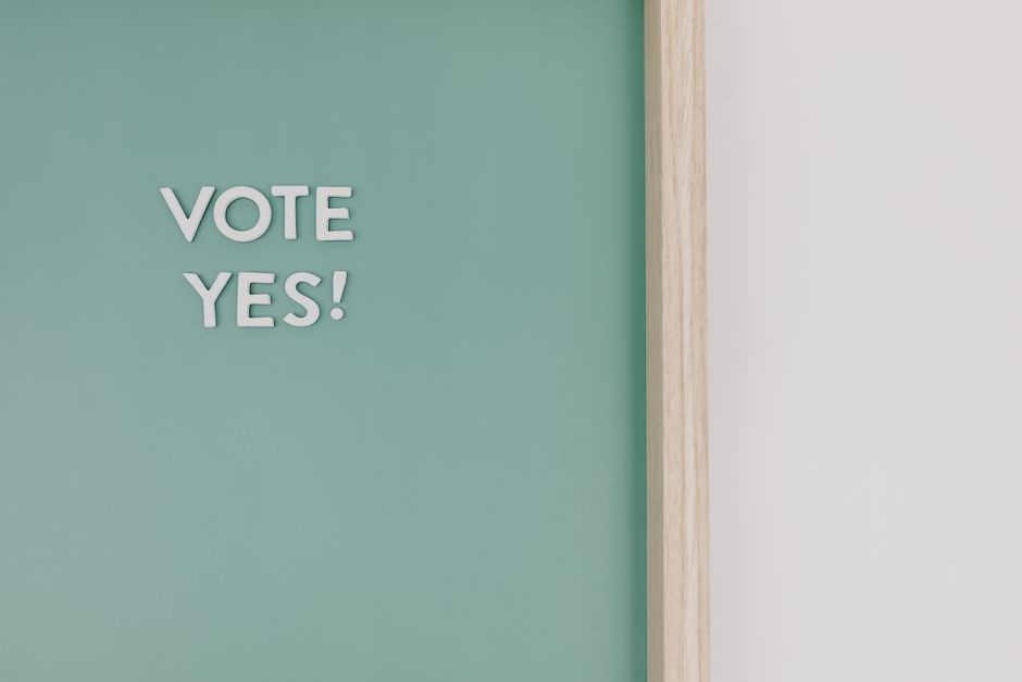Primer plano de una pizarra con el texto '¡Vota Sí!', ofreciendo espacio para copiar.