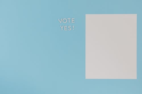 Free A Blank White Paper and a Vote Yes Text on a Blue Background Stock Photo