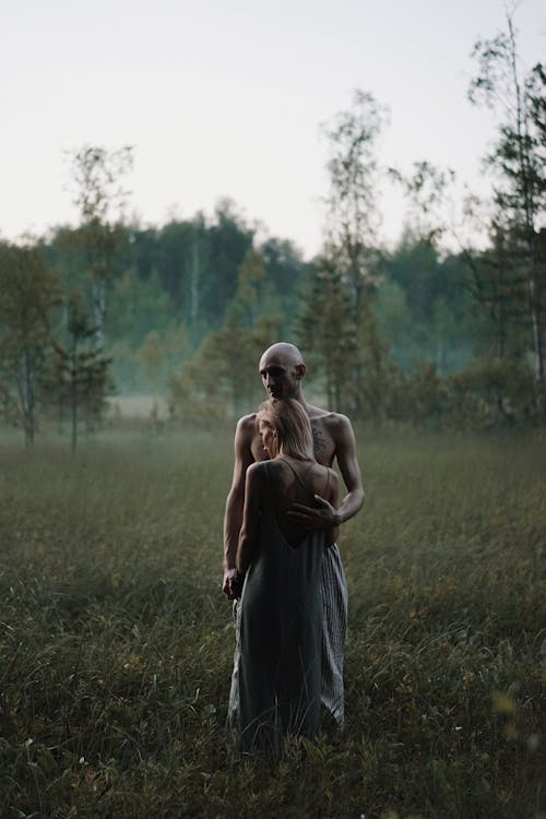 A Romantic Couple Standing on a Grassy Field