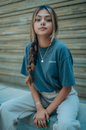 Woman in Blue Crew Neck T-shirt and White Pants Sitting on Floor