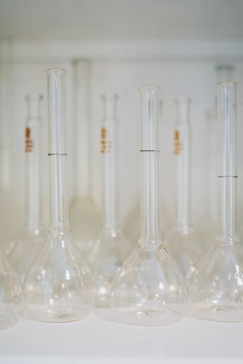 Free Close-up of transparent volumetric flasks arranged on a laboratory shelf. Stock Photo