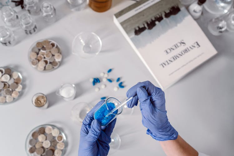 Person Holding A Glass Tube And Dropper With Chemicals