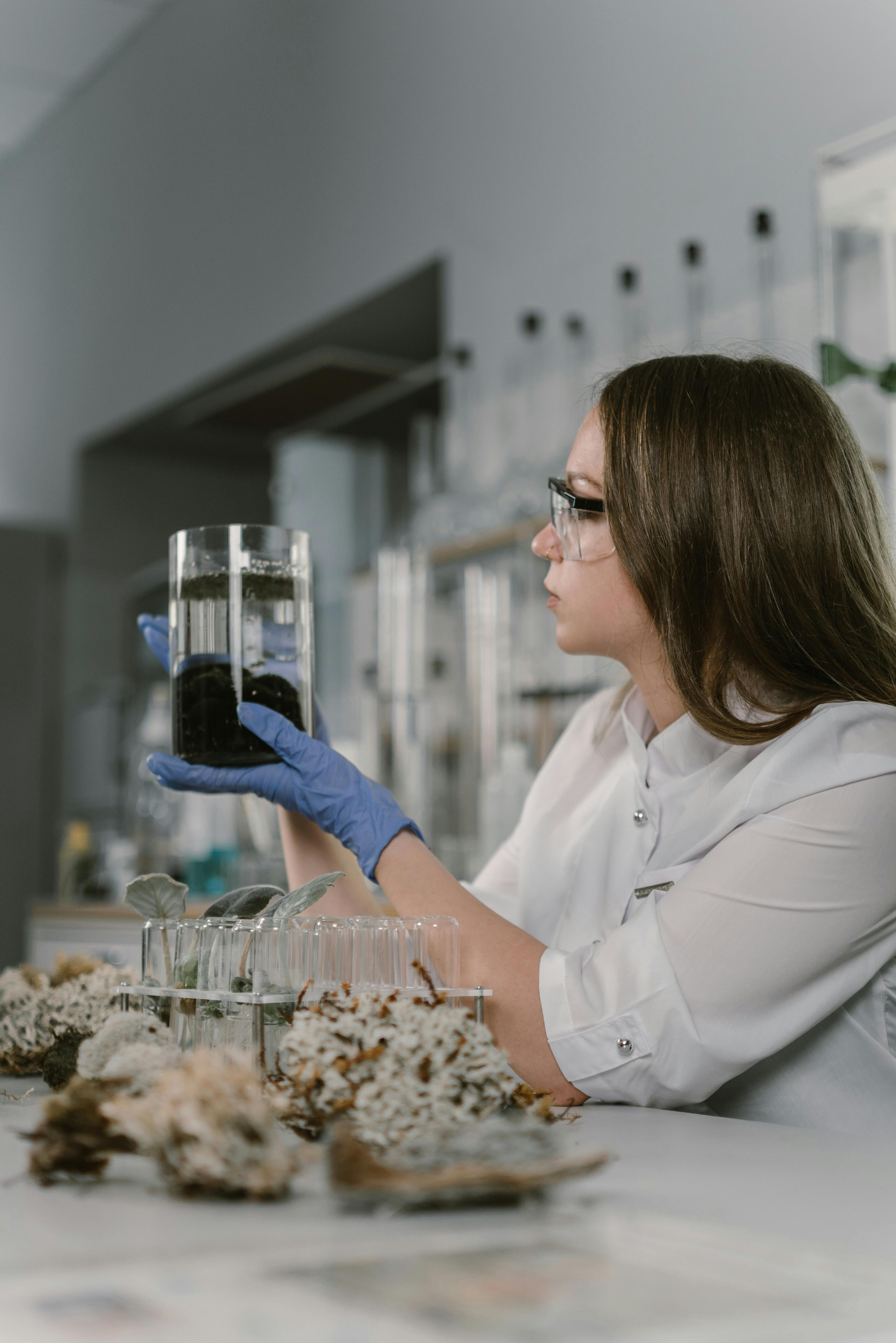 a woman holding looking at a chemical laboratory glassware