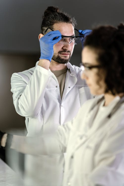 Scientists in Lab Coats Wearing Protective Goggles