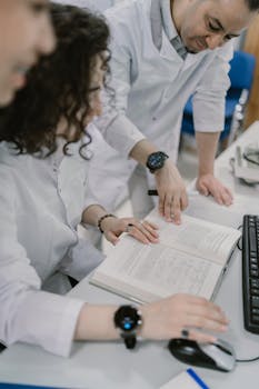 Scientists in lab coats reading a book and discussing chemical experiments in a modern lab.