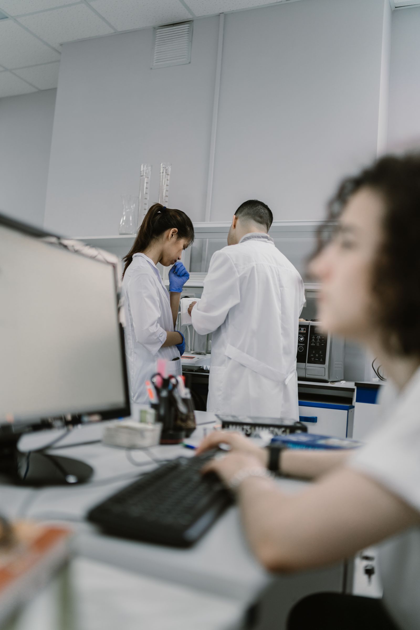 Laboratory staff working with diagnostic equipment in a modern medical lab