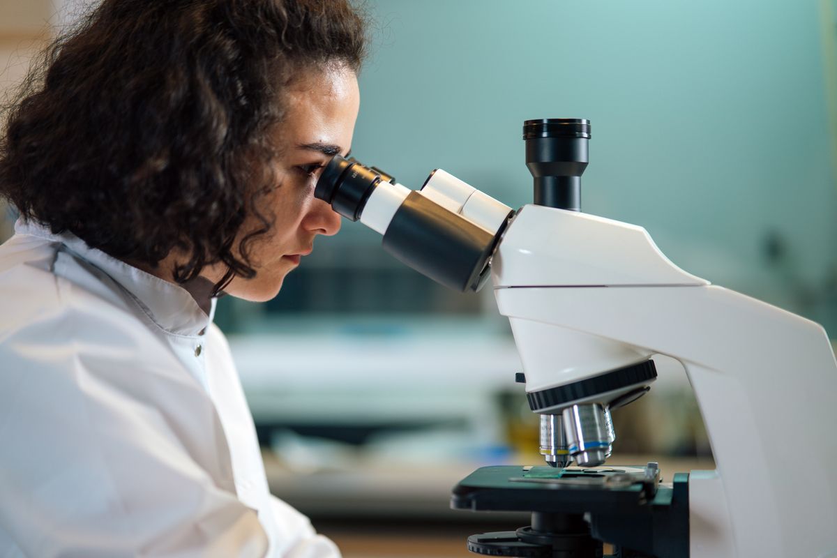 Researcher examining a sample under a microscope in a laboratory