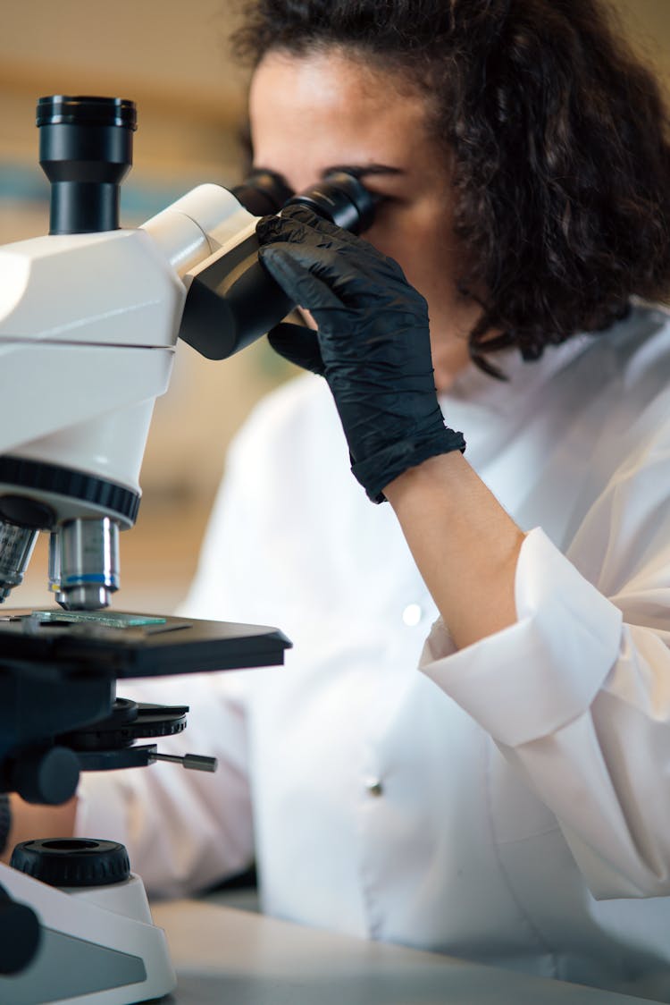 Scientist Wearing Lab Coat Using A Microscope