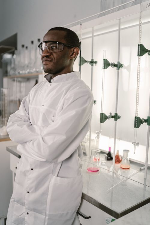 Free Confident scientist in lab coat with protective eyewear in modern laboratory. Stock Photo