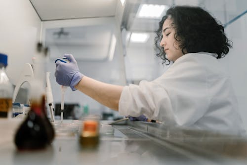 Free Woman Wearing Laboratory Gown Doing Experiment Stock Photo
