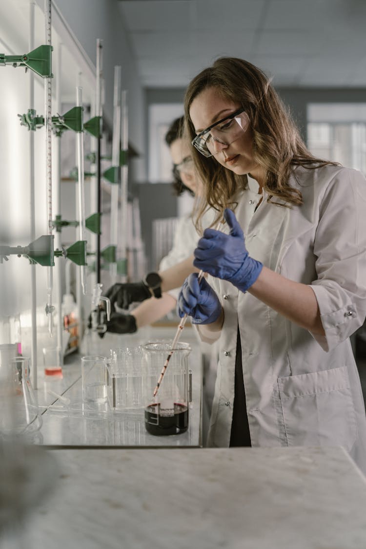 A Scientist Transferring Chemical Using A Pipette