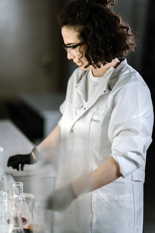 Woman Wearing Laboratory Gown Doing Experiment