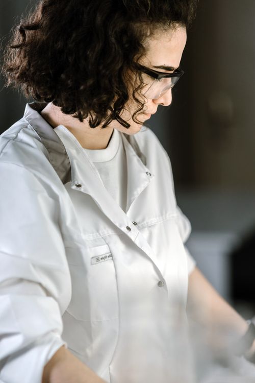 A Woman in White Uniform Wearing Safety Glasses · Free Stock Photo