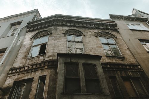 Free Discover the haunting facade of an abandoned building featuring arched windows and weathered stonework. Stock Photo