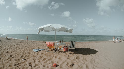 Umbrella and Beach Chairs on White Sand 