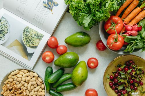 Free An appetizing display of fresh fruits and vegetables with a cookbook, perfect for healthy recipes. Stock Photo