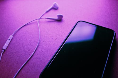 Close Up Photo of Cellphone and Earphones