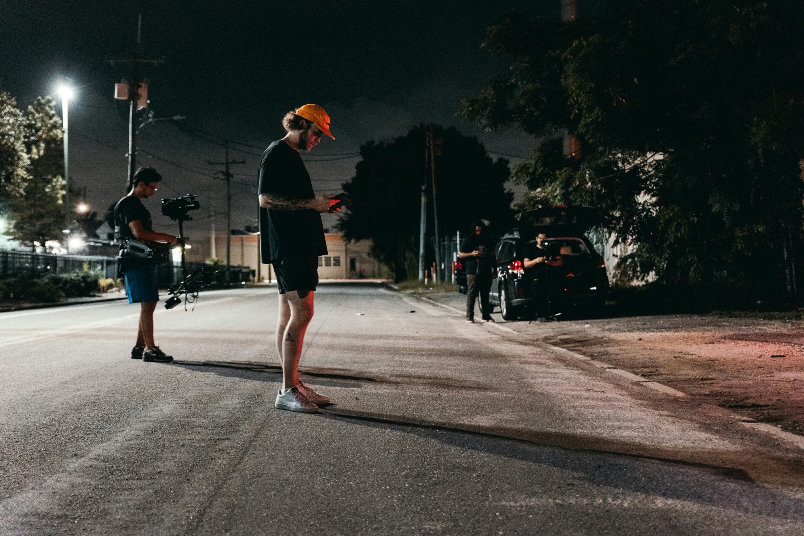 man in black long sleeve shirt and red hat walking on street