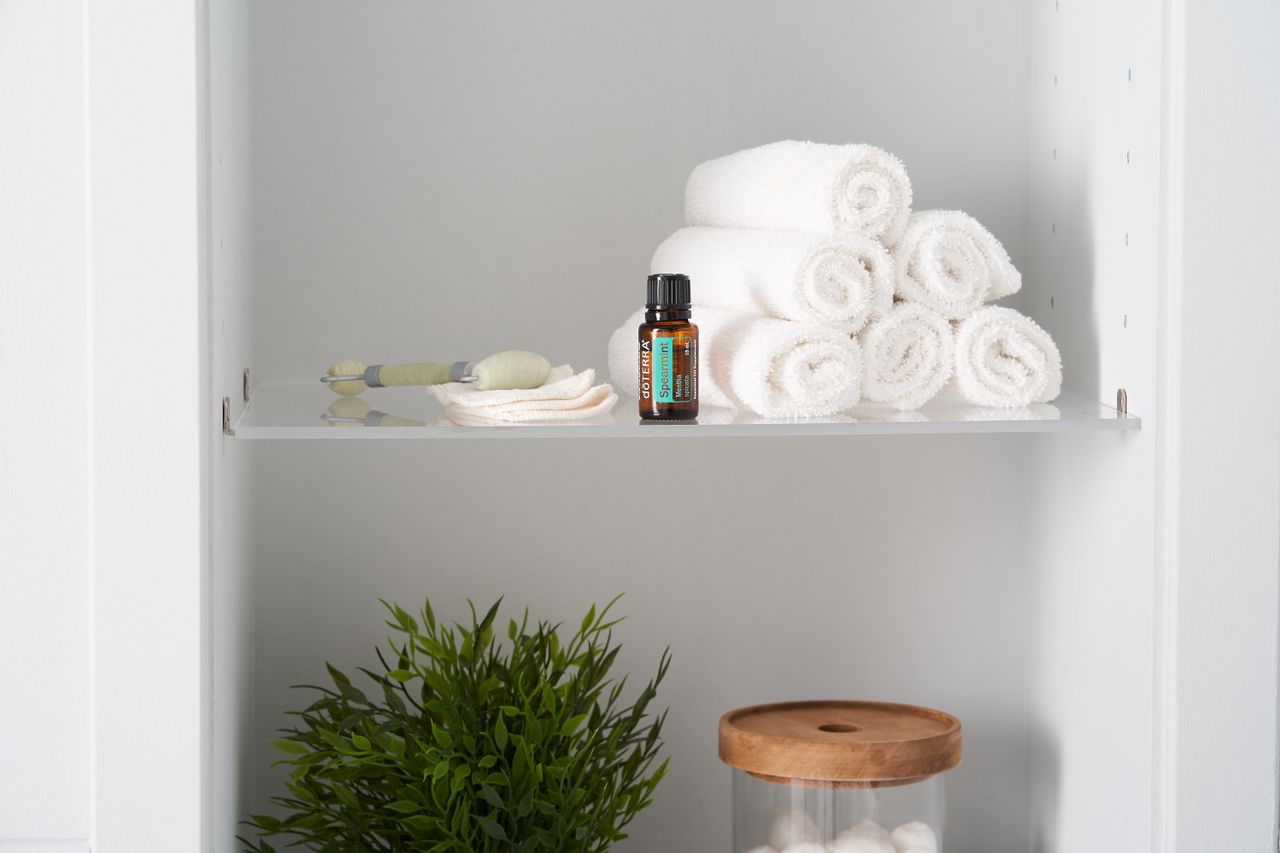 Rolled white towels on a glass bathroom shelf