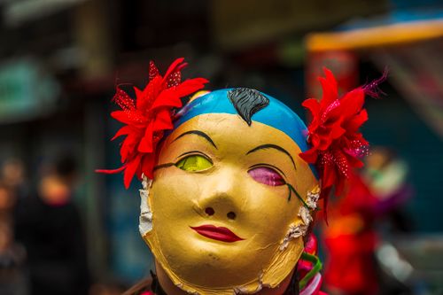 Free Vibrant close-up of a traditional mask with red flowers in Taipei street. Stock Photo