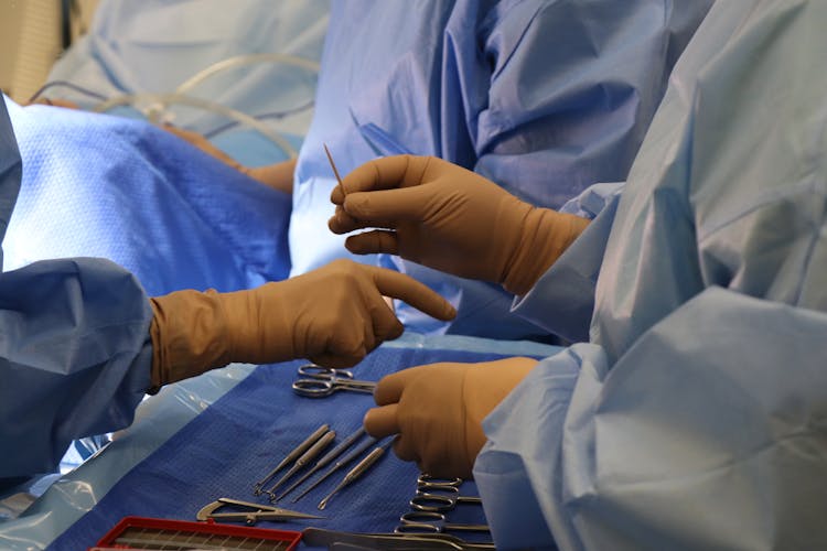 Hands Of A Surgeon And Nurses Passing Medical Tools