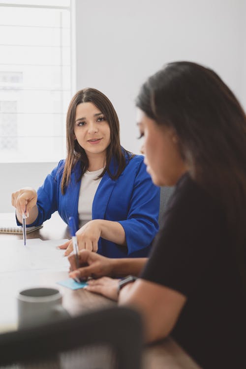 Free Woman Discussing Project with her Coworker Stock Photo