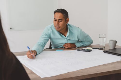 Free A focused professional strategizing work plans at an office desk with documents. Stock Photo