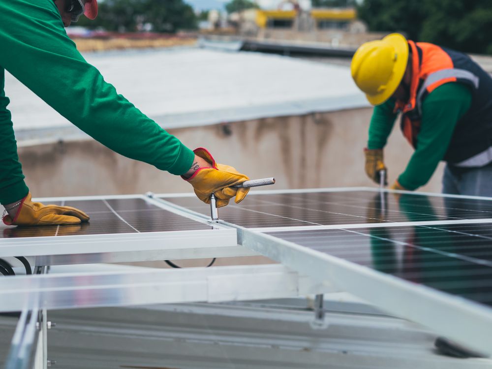 Workers installing solar panels on a rooftop