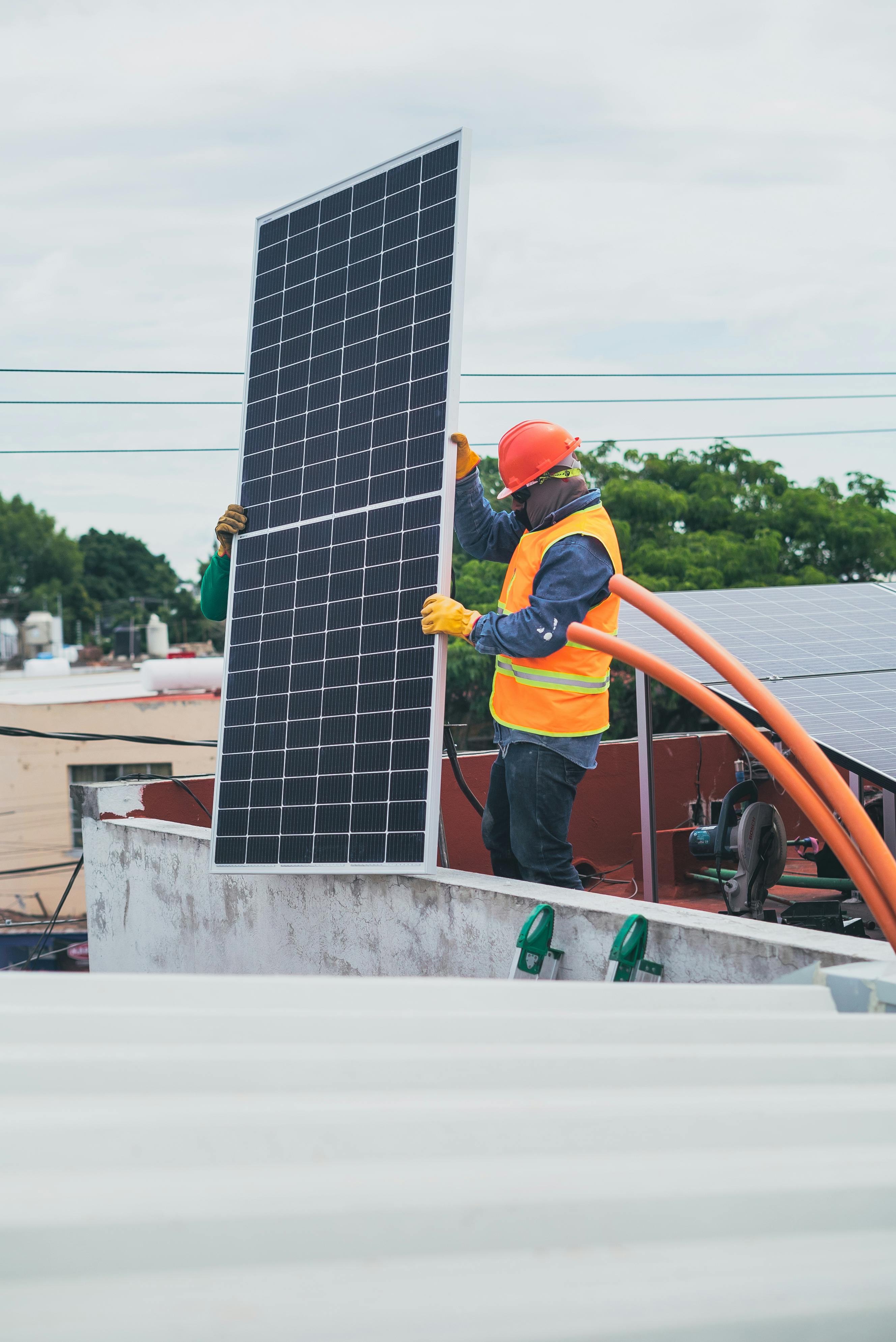 solar technician carrying solar panel