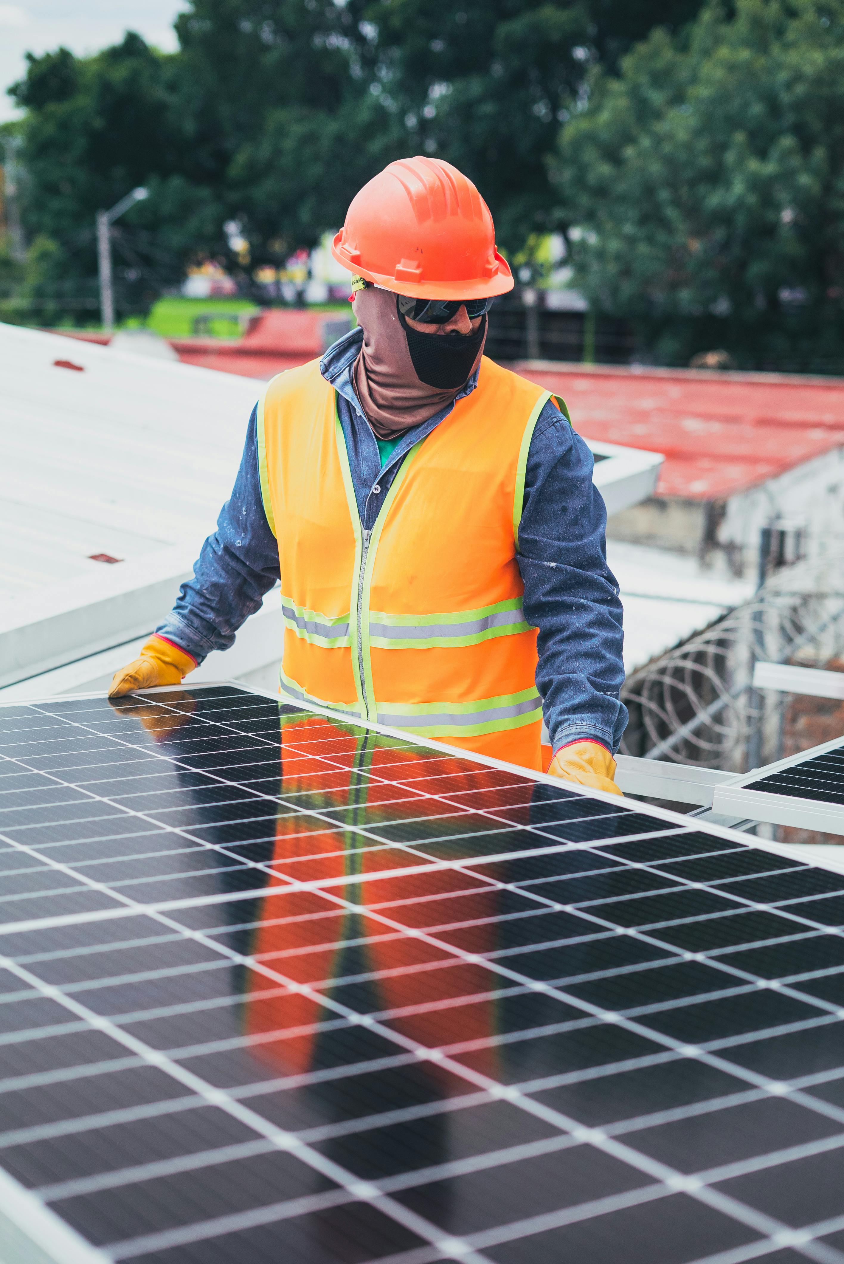 maintenance man standing beside a solar panel