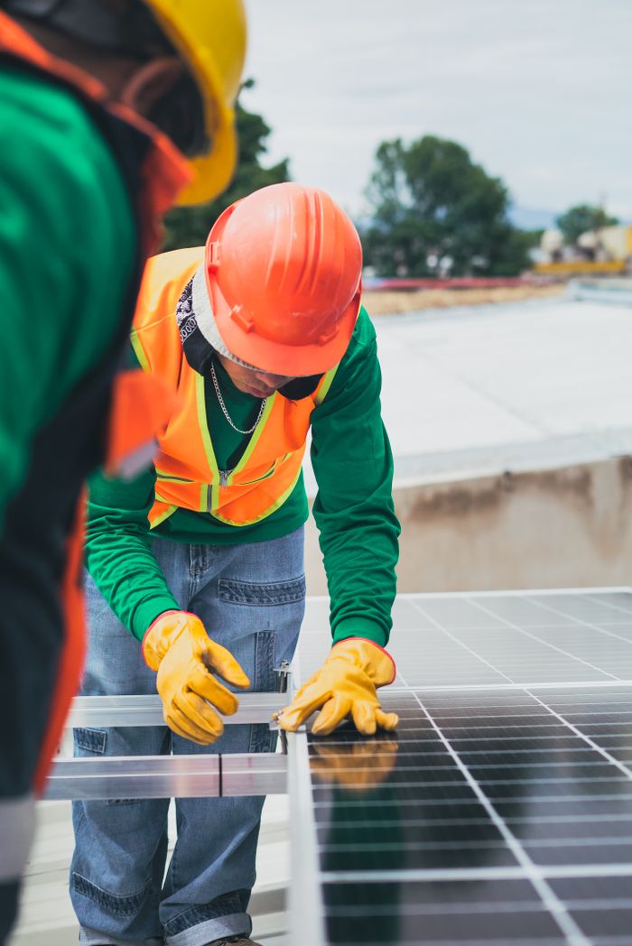 Solar technician installing a commercial rooftop solar array in Croydon, London