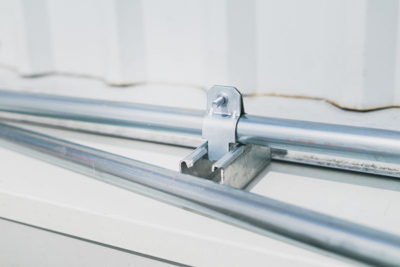 Metal pipe clamp on a stainless steel surface