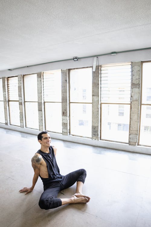 Man in Black Tank Top and Pants Sitting on Floor 