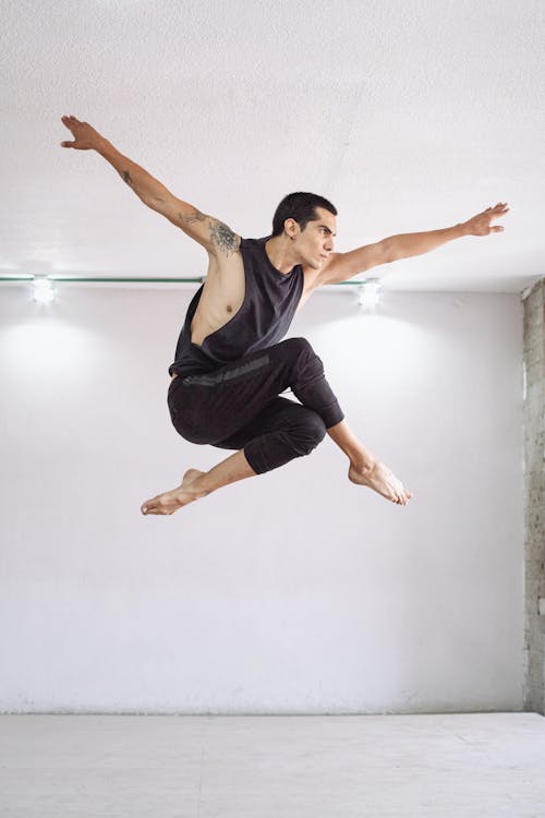 Jump Shot of Man in Black Tank Top and Pants 