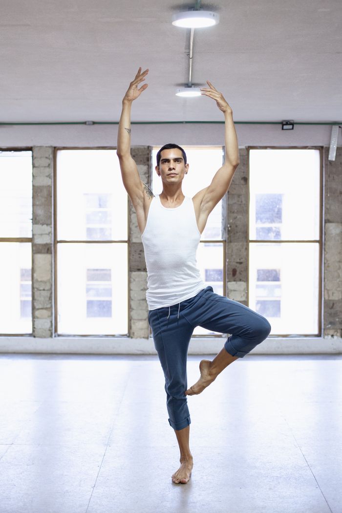 Male ballet dancer stretching in a bright studio