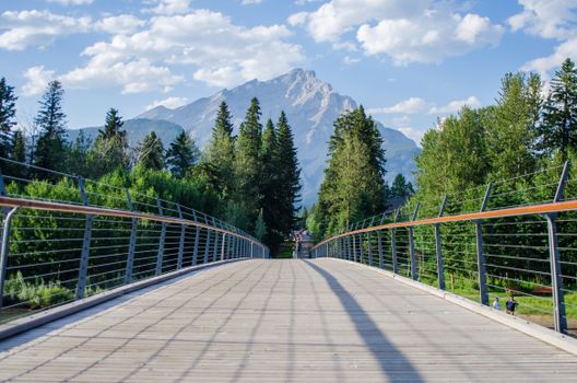 A picturesque view of a mountain landscape from a wooden bridge in summer.