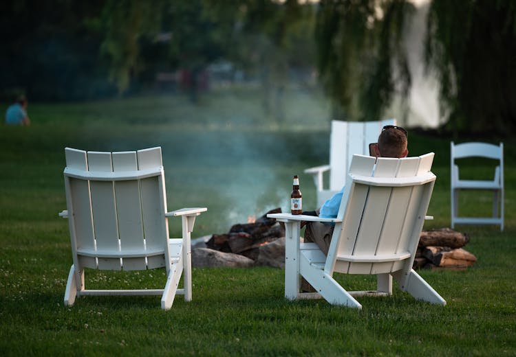 Man Sitting In A Garden Chair By A Fire