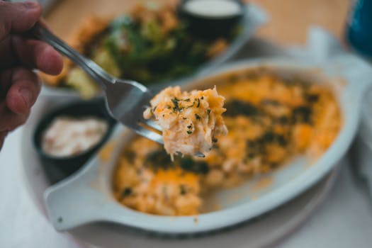 Tasty pasta dish with herbs on fork, close-up, inviting meal.