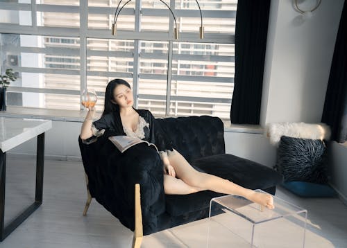 Free Woman in Sleepwear Sitting on Sofa Stock Photo