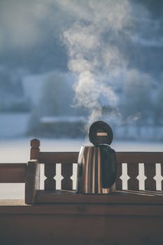 冬季的木阳台上，放着一把热气腾腾的电水壶