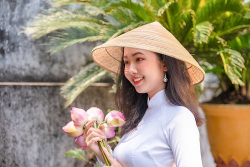 Free Beautiful Woman Smiling Wearing a hat and Holding Flowers Stock Photo
