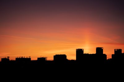 City buildings silhouetted against a sunset sky, photo by Aleksei Andreev on Pexels
