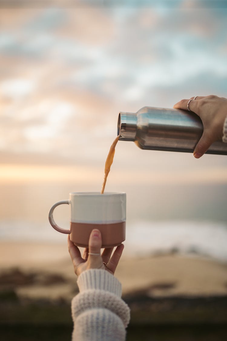 Person Pouring Coffee Into A Mug