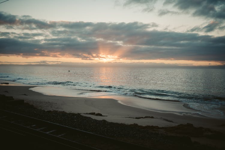 Waves Crashing On The Shore During Sunset