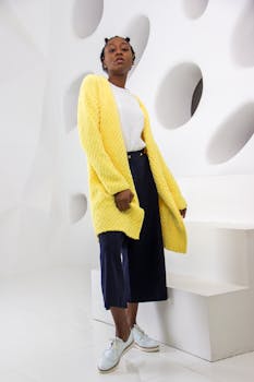 Fashionable woman posing in a stylish studio setting with modern white design.