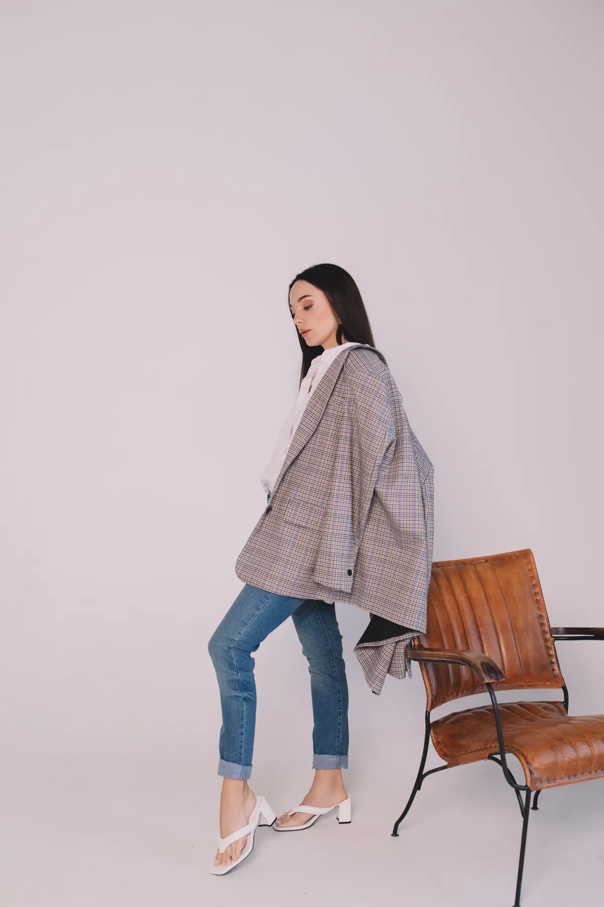 Perempuan tampil chic dengan mom jeans high waist dan oversized blazer untuk look retro semi formal