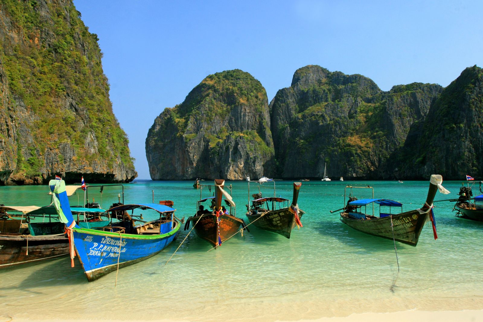 Thailand Budget Express - Long-tail boat in turquoise waters near Thai island